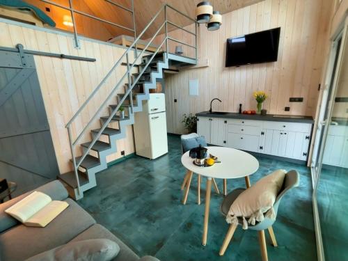 a living room with a table and a staircase at domek w stylu stodoły in Narty