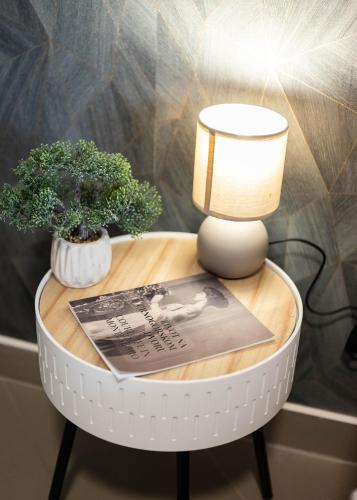 a table with a lamp and a plant on it at Studio Apartment Cudo Nevidjeno in Karuč