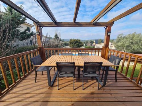 a wooden deck with a wooden table and chairs at MARGASOL in Pedrezuela