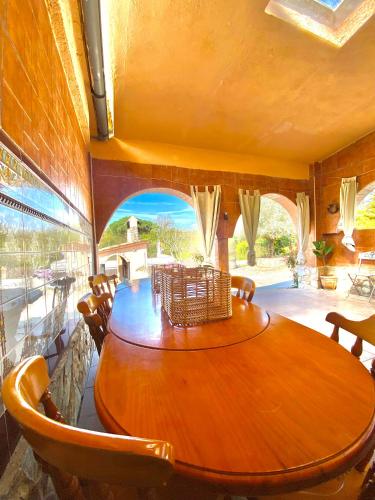 a dining room with a wooden table and chairs at Casa La Alegria in Maçanet de la Selva