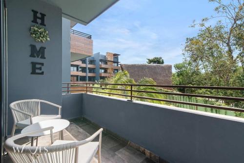 a balcony with two chairs and a table at Modern 1 Bedroom Apartment with Luxury Amenities at Paramar Black by Waves in Tulum