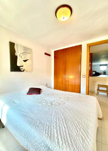 a bedroom with a white bed with a picture on the wall at Casa La Alegria in Maçanet de la Selva