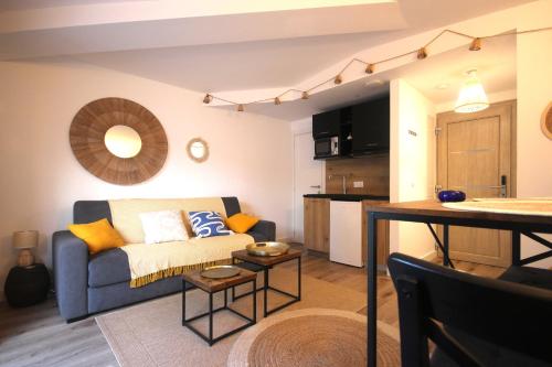 un salon avec un canapé et une cuisine dans l'établissement Studio grande piscine dans résidence hôtelière, proche plage, à Lecci