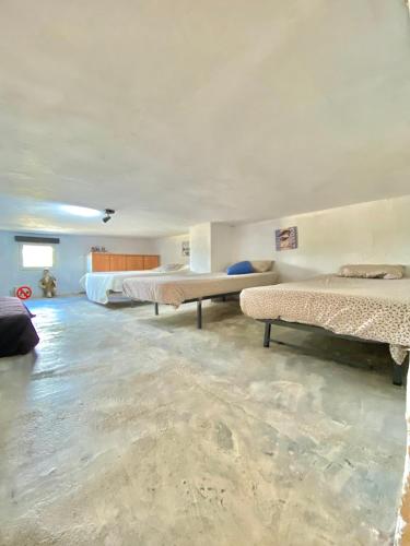 a large room with two beds and a couch at Casa La Alegria in Maçanet de la Selva