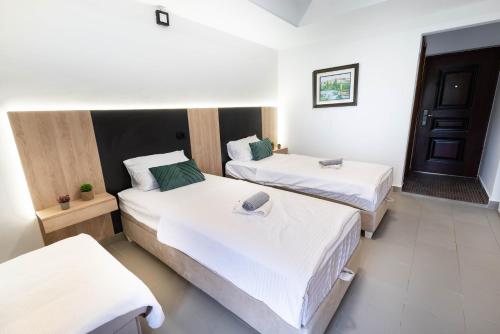 a room with two beds with white sheets at Studio Apartment Cudo Nevidjeno in Karuč