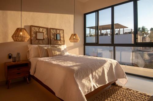 a bedroom with a bed and a large window at CASA ZOE- Cerca de playa in Puerto Escondido