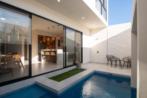a house with a swimming pool and a dining room at CASA ZOE- Cerca de playa in Puerto Escondido