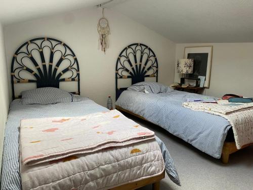 - deux lits dans une chambre avec deux jupons dans l'établissement Appartement piscine Cap Ferret 50m du Bassin et des commerces, à Lège-Cap-Ferret