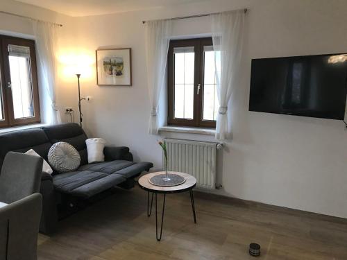 a living room with a couch and a tv on a wall at Ferienhaus Neuhold in Kitzeck im Sausal