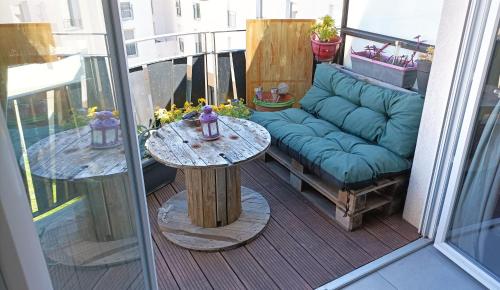 a patio with a couch and a table on a balcony at Magnifique T3 spacieux au calme à Castelnau Le Lez in Castelnau-le-Lez