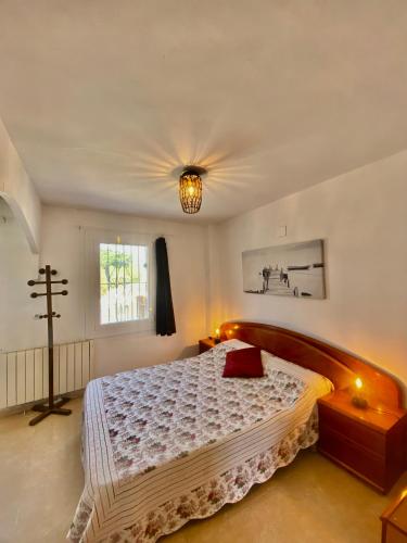 a bedroom with a bed and a cross on the wall at Casa La Alegria in Maçanet de la Selva