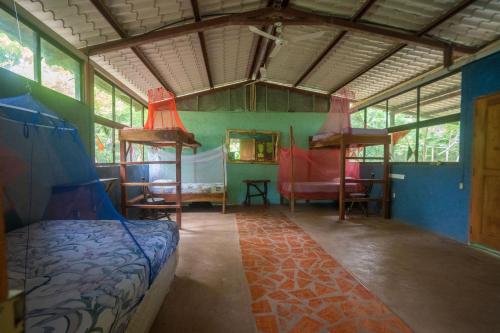 une chambre avec deux lits superposés et une table et des chaises dans l'établissement Hostal and camping Huellitas Ometepe, à Santa Cruz