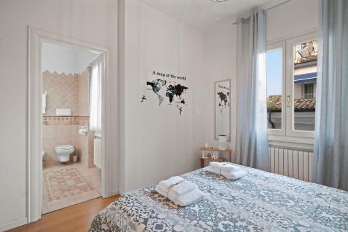 a white bedroom with a bed and a bathroom at La Dama sul Lago - fronte lago e parcheggio incluso in Desenzano del Garda
