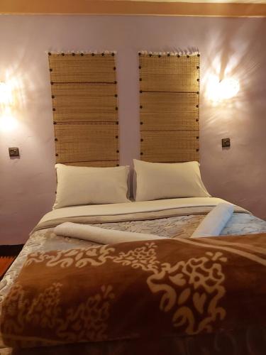 a bedroom with a large bed with two windows at DAR DANI café restaurant in Boumalne