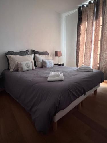 Un dormitorio con una cama grande con dos toallas encima. en Sarlat en Couleurs, en Sarlat-la-Canéda