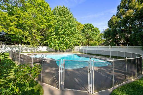 a swimming pool with a metal fence around it at Private completely fenced in property Near beach in Hampton Bays