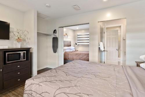 a bedroom with a large bed and a television at Oasis Inn in Kelowna