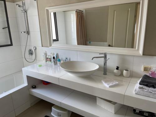 a white bathroom with a sink and a mirror at Beautiful Penthouse w/amazing View, Prime location in Ramat Gan