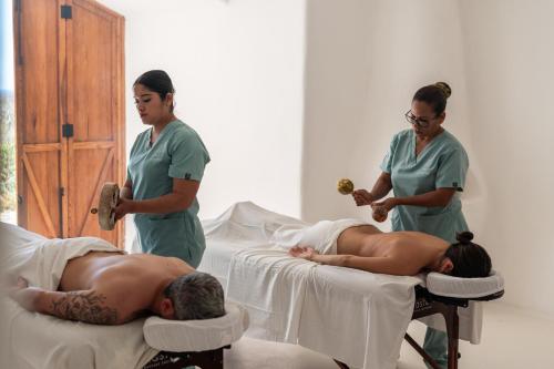 two women in a hospital room with a man laying on beds at NEST Baja in San José del Cabo