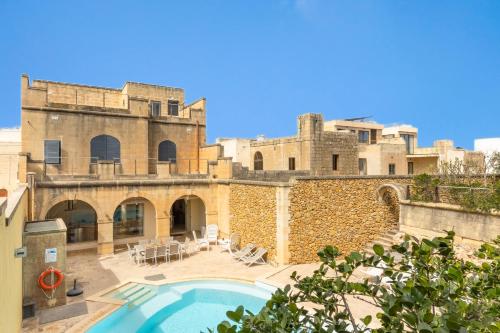 a swimming pool in front of a building at OneFifty Gozitan Villa and Pool in Il-Pergla