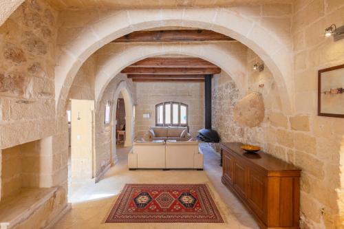 an archway in a room with a couch and a table at OneFifty Gozitan Villa and Pool in Il-Pergla