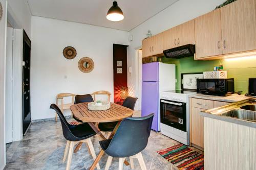 a kitchen with a table and chairs in a kitchen at Κήπος μέ τις πορτοκαλιές in Mytilini