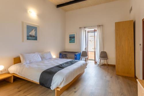 a bedroom with a large bed with a wooden floor at OneFifty Gozitan Villa and Pool in Il-Pergla
