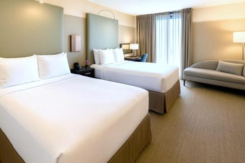 a hotel room with two beds and a couch at Crowne Plaza - Chicago West Loop by IHG in Chicago