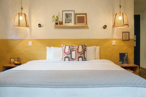 a bedroom with a large white bed with two pillows at Hotel Plantación in Jardin