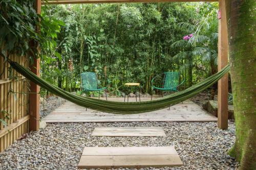 a hammock in a garden with chairs and a table at Hotel Plantación in Jardin