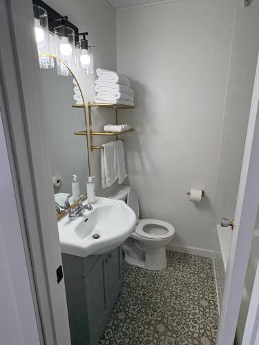a white bathroom with a sink and a toilet at Remo Stays in Unity