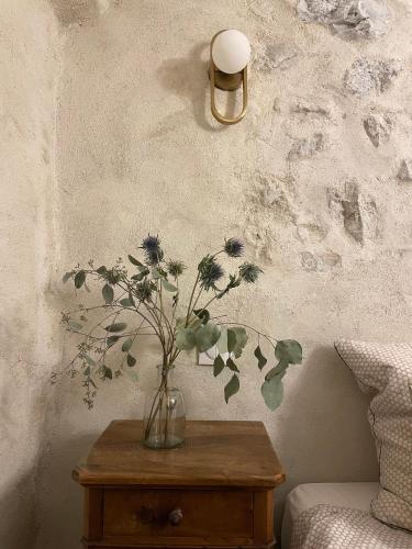 un vase avec des fleurs sur une table dans une chambre dans l'établissement La Maison de Vergol, à Montbrun-les-Bains