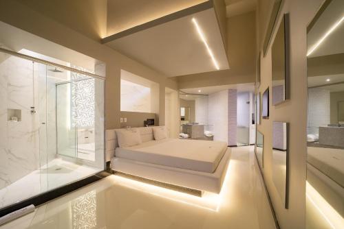 a large bedroom with a bed and a shower at Motel Platinum in Londrina
