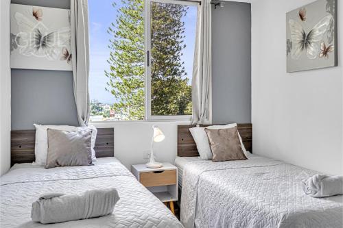 Dos camas en una habitación con dos ventanas. en Cozy, Modern and Centric Apartment with pool and gym, en San Salvador