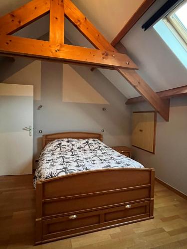 une chambre avec un lit dans un grenier dans l'établissement Aux charmes de la campagne, à Millières