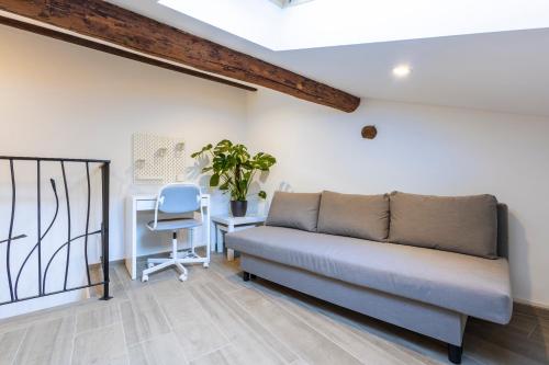 a couch in a room with a desk and a chair at Torre delle Rondini in Isolabona