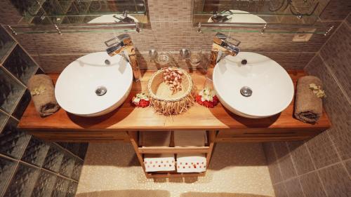 two sinks on a wooden table in a bathroom at Manja Kely Lodge in Nosy Be