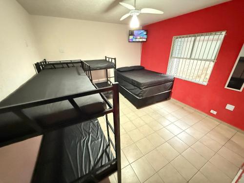 Habitación con 2 literas y pared roja. en Pie en la arena Playa de Ocean IV, en Samaritá