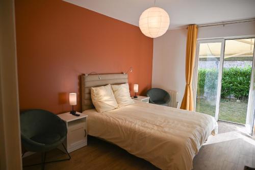 une chambre avec un lit et deux chaises et une fenêtre dans l'établissement Le jardin de Fontainebleau, à Fontainebleau