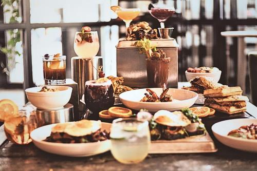 a table topped with plates of food and drinks at Crowne Plaza - Chicago West Loop by IHG in Chicago