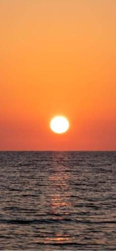 an orange sunset over the ocean with the sun at Aurora e Alba in Casalabate