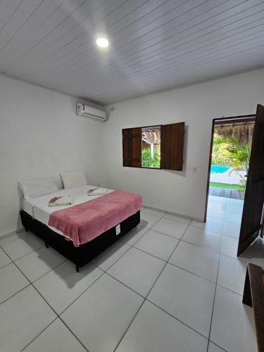 a bedroom with a bed and a large window at Suítes Milagres Bontempo in São Miguel dos Milagres