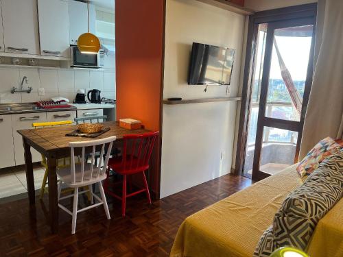 a small kitchen with a table and chairs in a room at Apto com sacada e vista vale dos vinhedos in Bento Gonçalves