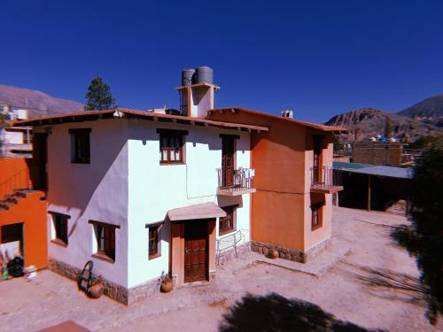 a large white house with a roof at Departamentos Complejo Turístico Cruz Mendoza in Tilcara
