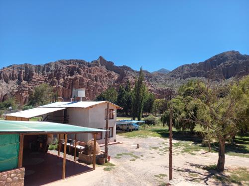 a building with a mountain in the background at Departamentos Complejo Turístico Cruz Mendoza in Tilcara
