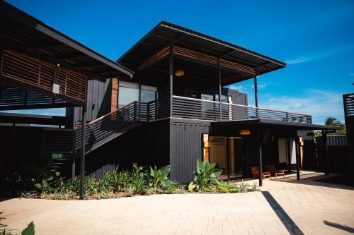 a black house with a balcony and a patio at Wao Beach Venao in Playa Venao