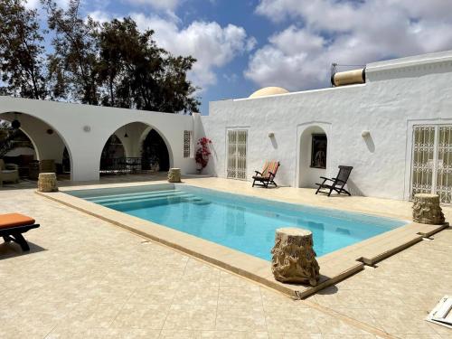 a swimming pool in the backyard of a house at Dar Néliah Djerba in Djerba