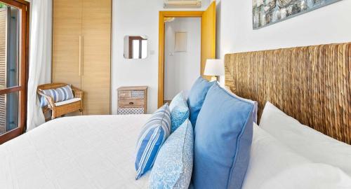 a bedroom with a bed with blue pillows at Beautiful Apartment BJ12 with Amazing Sea Views, Aphrodite Hills in Kouklia