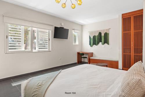 a white bedroom with a bed and a window at Ayana Inn PR in San Juan