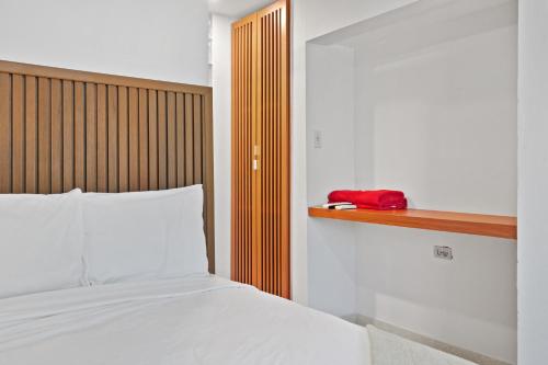 a bedroom with a bed and a red phone on a shelf at Ayana Inn PR in San Juan